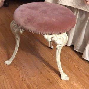 A small stool. It needs repair. Pink velvet attached with pins.